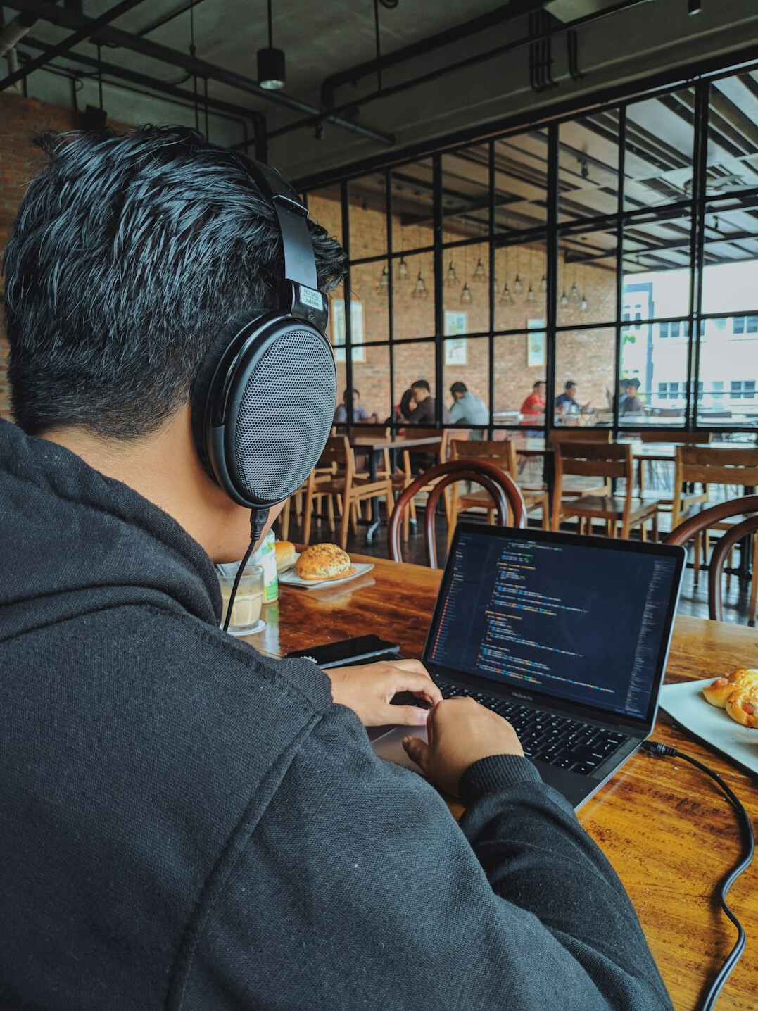 person coding on laptop in cafe